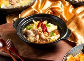 Sichuan Style Winter Noodles Claypot with fork and spoon served in dish isolated on wooden board side view of asian food photo