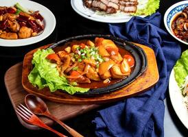 Sizzling tofu with tomato, spring onion, spoon and fork served in dish isolated on wooden board side view of taiwan food photo