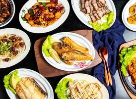 fried fish jaw roast, Pan fried fish maw, Pineapple Shrimp Balls, Sizzling tofu, grilled salted pork, Kung Pao Chicken, Braised pig feet served in dish isolated on board top view of taiwan food photo