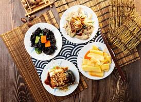 assorted taiwan side dishes Black Fungus, Pork liver, Crispy bamboo shoots, Preserved egg tofu, with chopsticks served in dish isolated on napkin top view on table taiwan food photo