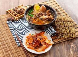 de repuesto costillas fideos conjunto con cerdo cuero cabelludo, Preservado huevo, palillos servido en plato aislado en servilleta lado ver en mesa Taiwán comida foto