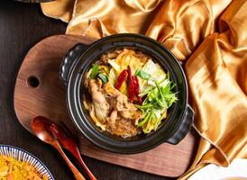 Sichuan Style Winter Noodles Claypot with fork and spoon served in dish isolated on wooden board top view of asian food photo