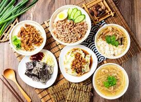 Roasted duck rice, Pork rice, Blanched vegetables, Duck blood rice cube, Ancient style mushroom and meat soup rice, with spring onion, served isolated side view on table assorted taiwan food photo