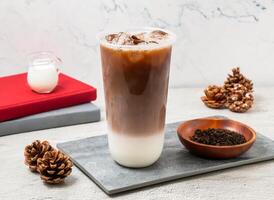 Iced Oolong Latte served in disposable glass isolated on board side view of taiwanese iced drink photo