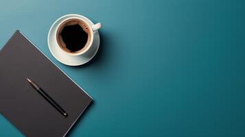 A Cup of Coffee and a Pen on a Blue Surface photo