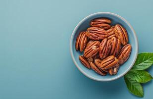 Bowl Filled With Nuts and Leaves on Blue Surface photo