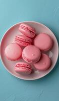 Plate of Pink Macaroons on Blue Table photo