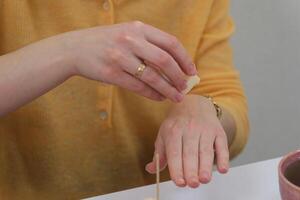 The process of making a massage candle using ingredients oils and wax measure weigh stir add close-up of women's hands. food thermometer measure wax temperature women's party women witches witchcraft photo