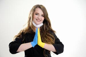 Let's pray for Ukraine female doctor folds two hands in latex gloves yellow and blue like flag of Ukraine stretches hands gives love calls for help salvation of Ukraine war terror Russia photo