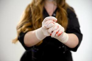 Hand showing stop sign in latex glove with blood. The bloody hand isolated on white background. Social violence and insecurity concept. Part of set. photo