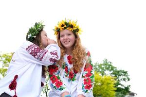 whisper in the ear of a girlfriend gossip two beautiful girls with red hair laugh against the backdrop of a white sky and green trees spend time together joking At a party they flirt with the guys photo