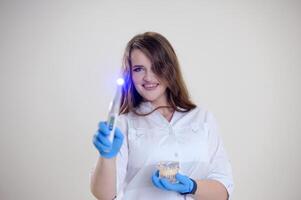 Beautiful young woman with healthy teeth and tooth fairy on white background photo