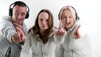 hombre y dos mujer Adolescente niña haciendo negativo columpio con índice dedo No no lo hagas hacer eso Mira dentro el marco extensión mano con dedo adelante auriculares chándales blanco antecedentes foto