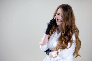 woman in white clothes doctor talking on the phone Hand in black glove holding mobile phone with blank screen on white background. Isolated with clipping path. photo