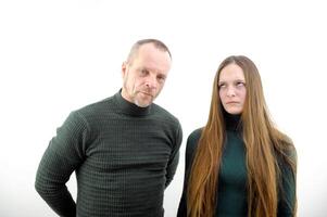 Negative emotions, quarrel, grievances and disagreements. Offended young male and female with crossed arms turned away and looking at each other, isolated on gray background, studio shot, copy space photo