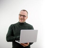 middle-aged man balding in glasses holding laptop joyful fun joy to students a lecture for lectures with a laptop a salesman in a laptop store an experienced marketer sells a gadget to customers photo