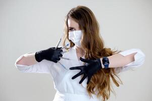 Beautiful woman dentist in a black suit with a white mask with flowing hair holds in her hands scaler and curette Hand stretched forward selective focus bright photo of gorgeous woman