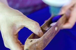 Hands Weaving Fabric with Traditional Wooden Tool photo