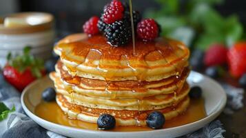 Stack of Pancakes With Syrup and Berries on a Plate photo