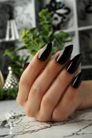 Womans Hand With Black and White Nail Polish photo