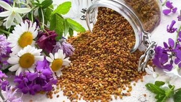 Healthy bee pollen grains. Bee pollen on a glass jar and wild flowers video