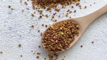 Healthy bee pollen grains. Bee pollen on a wooden spoon video