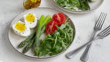 fresco Primavera salada com fervido ovos, espargos, e tomates em uma brilhante dia video