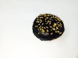 A chocolate donut with peanut chunks isolated on white background. Breakfast pastry donut. Room for text. Copy space. photo