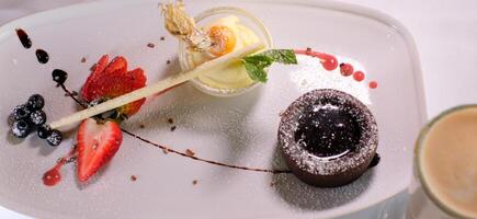 Chocolate fondant with strawberries, Chocolate fondant with strawberries and spoon on plate, isolated on white background, top view photo