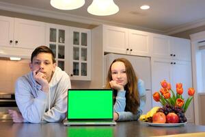 in the kitchen two teenagers with a computer laptop green screen chromakey advertising place for text offer buy sale delivery flowers everything you need photo