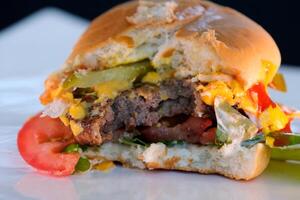 hamburguesa en un plato tomar un mordedura de un mordido emparedado delicioso comida Cocinando cena comunicar foto