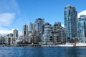 low fly over false creek granville island yaletown harbor with kayakers paddling yachts parked docks empty under the Granville Street Bridge next to luxury futuristic condominiums in the summer GFE1-8 photo