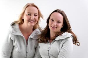 close-up faces of European women, an adult and a young girl looking into the frame, mother and daughter pointing with a finger, breaking hair white background photo