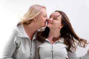 Adorable lovely fun satisfied elder parent mom with young adult daughter two women together wearing casual clothes hugging cuddle close eyes isolated on plain blue cyan background. Family day concept photo