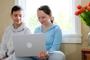 boys girl sitting near the computer teenagers watching a movie smiling pleasant pastime first relationship date love in adolescence Tenderness flowers gift invite to be girlfriend photo