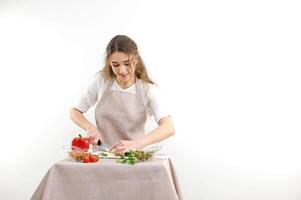 Green vegan salad with mixed green leaves woman eating salad at table with organic vegetables, enjoying healthy diet, standing in light kitchen interior. Lady cooked veggie meal Weight loss concept photo