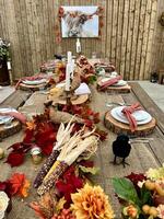 Wooden huge Table massive on which there are devices on wooden stands Mystical mysterious Halloween crows and other golden birds sit on the table Autumn bright orange and yellow flowers dry up photo