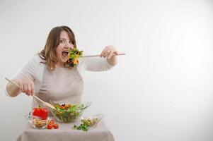 Portrait of happy playful woman Funny open mouth wide space for advertising cooking blog cook dinner salad bowl and winking isolated on white background raised her head and laughs out loud sincerely photo