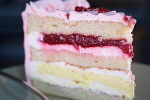 close-up of a piece of cake with cherries being unwrapped from the package. bakery cake. appetizing piece of cake with cherry. selective focus photo