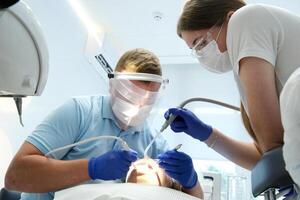 young girl showing heart with hands dental office brushing teeth whitening dental procedures doctor and nurse saliva suction and other latest technologies in blue gloves and masks self care favorite photo