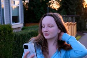 City street woman using smart phone at sunset photo