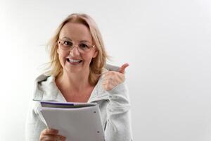 thumb up woman with glasses laughing blonde reading a white notepad on a light background sincere smile write down ideas come up with interest advertising proposals write a book photo