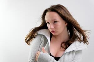 hair develops in the studio young girl teenager waves her head from right to left slow motion gray sports jacket black top adolescence innocent virgin beauty photo