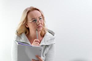 a journalist describes the situation wearing glasses, a middle-aged woman with a notepad listens attentively looks into the frame blond hair raises her finger up photo