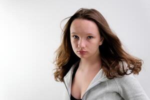 Face of charming European lady with curling wave hair and perfect skin pose at white background. Adorable seductive feminine in beautiful dress close up. Shot with RED camera in 4K photo