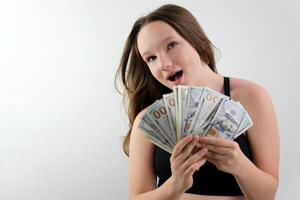 Young Happy Woman in gray sweater which holding money and looking at camera photo