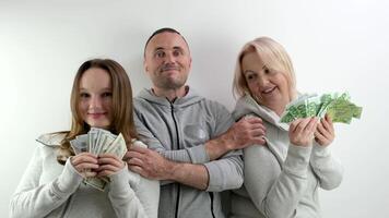 happy rich family dollars and euros in hands of mom daughters dad father hugs smiling happy waving money like fan on white background a lot of money luck travel in games kissing relatives on the head photo