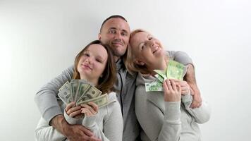 happy rich family dollars and euros in hands of mom daughters dad father hugs smiling happy waving money like fan on white background a lot of money luck travel in games kissing relatives on the head photo