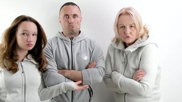 three dissatisfied indignant people a man two women a young teenage girl middle-aged people look evilly into the frame and dance an angry look photo