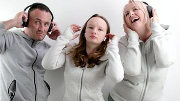 good positive-psychological relations in the family approval teenage girl dancing on a white background in headphones the girl shows the movement of the parents raise their thumbs up they like photo